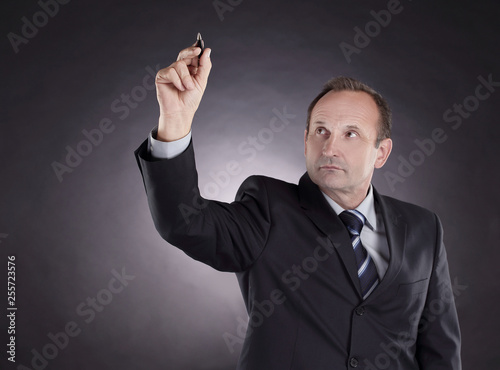 businessman writing on a virtual chalkboard. photo on black background