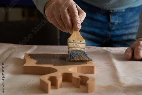 man covers a chopping board with special oil in the production hall