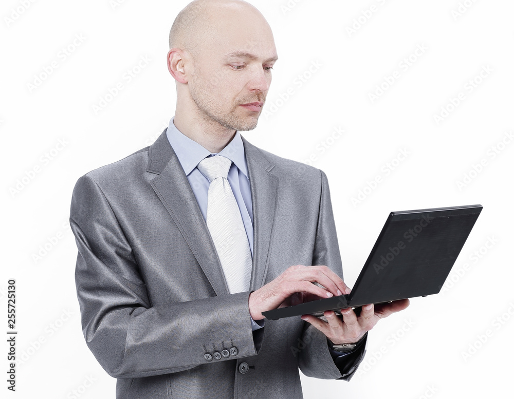 attentive businessman standing with a laptop.isolated on white attentive businessman standing with a laptop.isolated on white