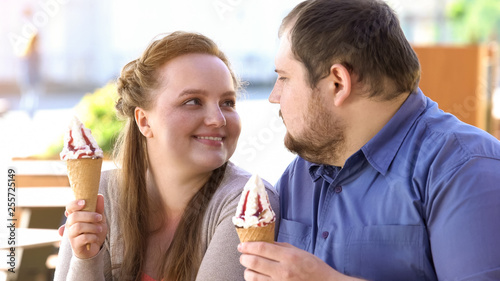Happy couple holding ice-cream and looking at each other  delicious dessert