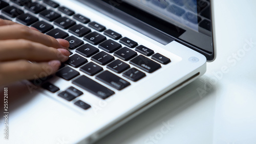 Hand typing laptop keyboard close-up , personal computer use at office or home