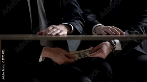 Politician hands taking bribe money under office table, lobbying of interests photo