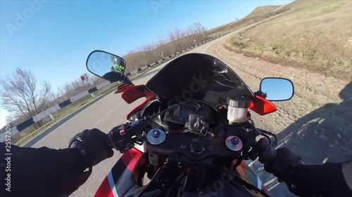 Riding a motorcycle on a country road, viewpoint of a biker riding down a scenic and empty road POV