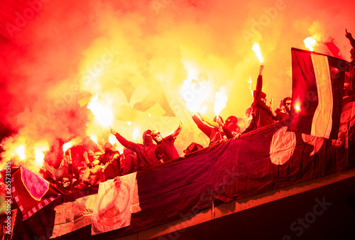 football hooligans with mask holding torches in fire