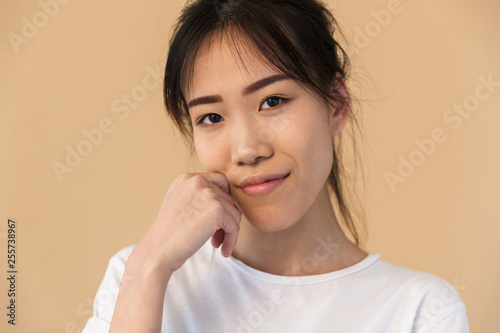 Photo of beautiful korean woman wearing basic t-shirt smiling and looking at camera