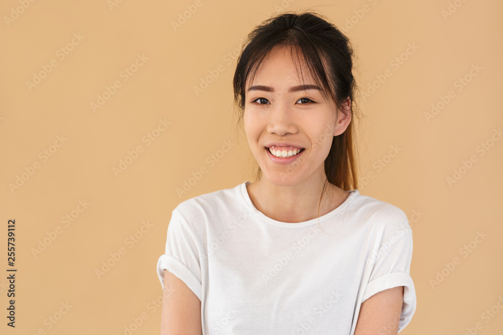 Portrait of friendly asian woman wearing basic t-shirt smiling and looking at camera Portrait of friendly asian woman wearing basic t-shirt smiling and looking at camera