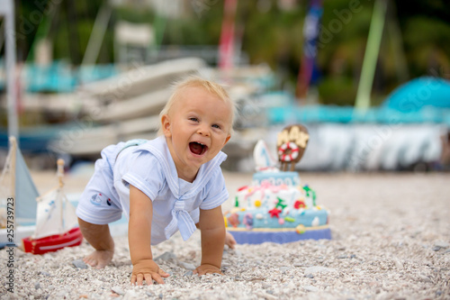 Sweet baby boy, celebrating first birthday with sea theme cake and decoration