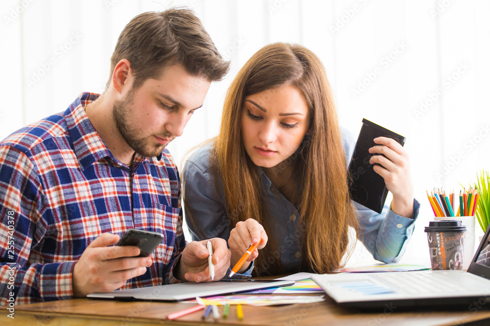 Obraz premium Two young creative designer colleagues using tablet at office