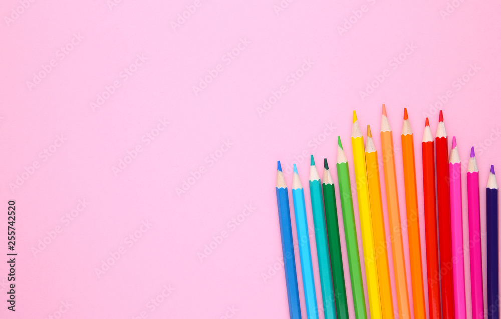 Many different colored pencils on pink background Many different colored pencils on pink background