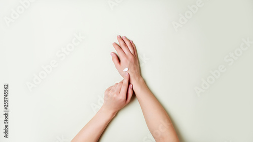 Woman hands on light green background.