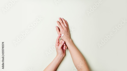Woman hands on light green background.