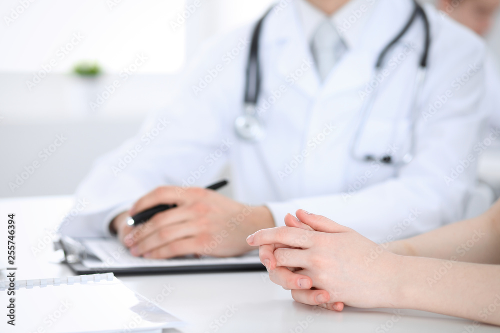 Doctor man and patient are discussing something, just hands at the table. Medicine and health care concepts Doctor man and patient are discussing something, just hands at the table. Medicine and health care concepts