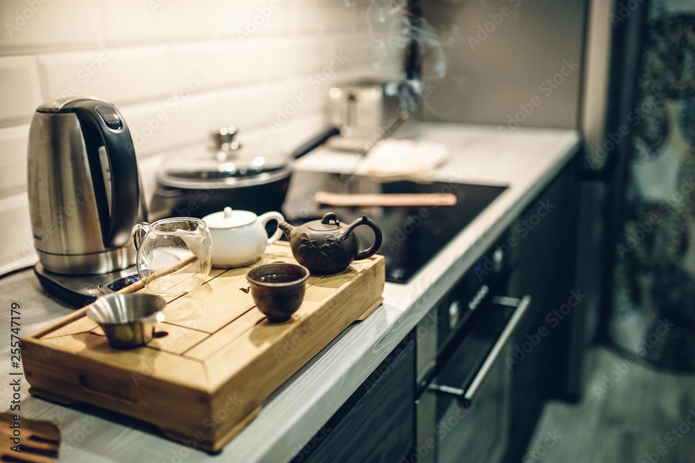 Chinese tea Pu-erh in a modern kitchen interior, a classic tea ceremony in pottery on a wooden podium Chinese tea Pu-erh in a modern kitchen interior, a classic tea ceremony in pottery on a wooden podium