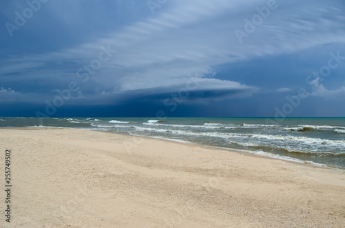 Sea waves wash the clean sandy beach. Landscape on a wild beach. Sea storm.