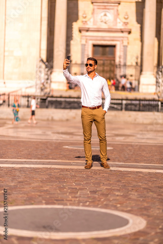 A businessman on a square taking a selfie 