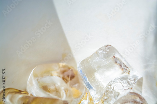 Cubes of large ice from a glass with strong coffee. Alternative Cold Brew drink. Play of color and patches of light. 