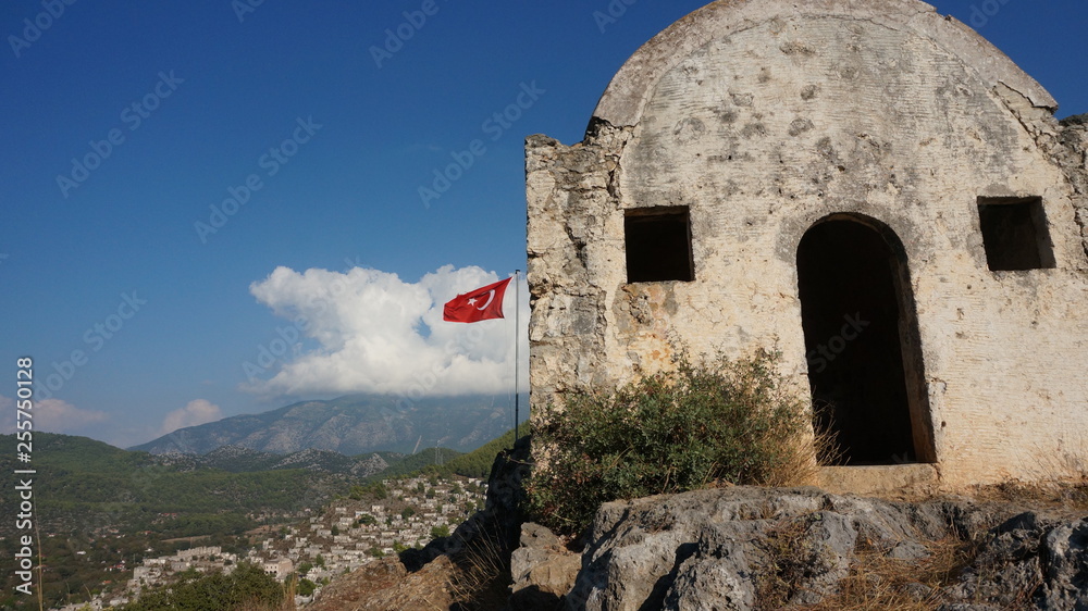 Turkish Flag flying in the Ghost Town kayakoy. Fethiye, Turkey.