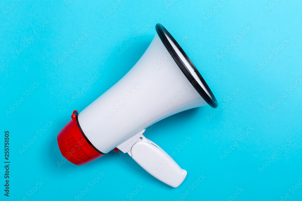 Fototapeta premium A megaphone on a blue paper background