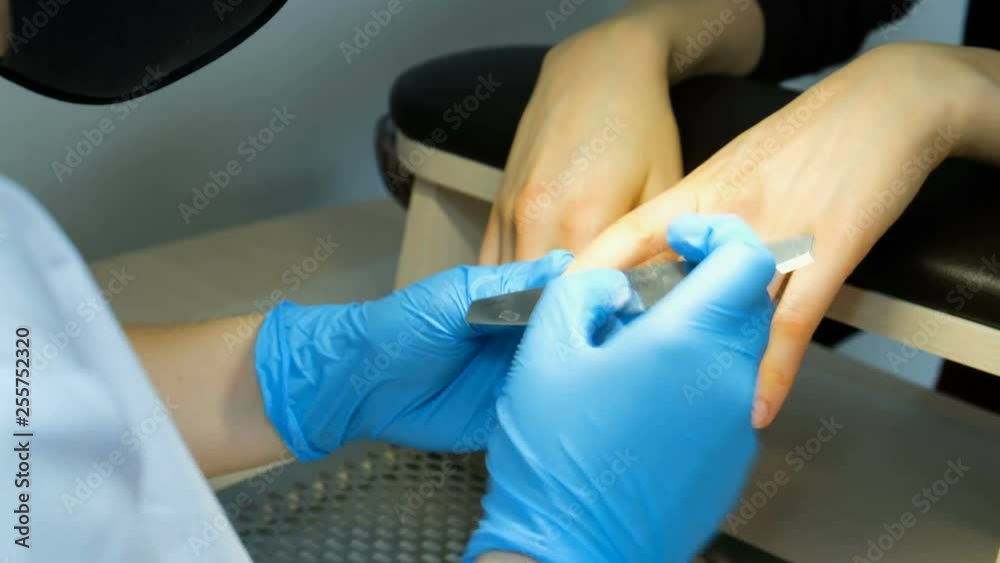 Manicure closeup. Manicurer files nail files, cleansing nails from old varnish Manicure closeup. Manicurer files nail files, cleansing nails from old varnish