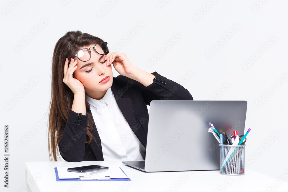 Beautiful businesswoman is very tired , she is working with her gray laptop on white background. Business concept. Beautiful businesswoman is very tired , she is working with her gray laptop on white background. Business concept.