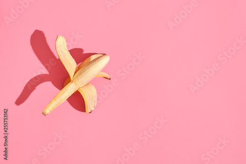 Composition of fresh fruits, whole fresh tasty banana without skin on pink background, top view