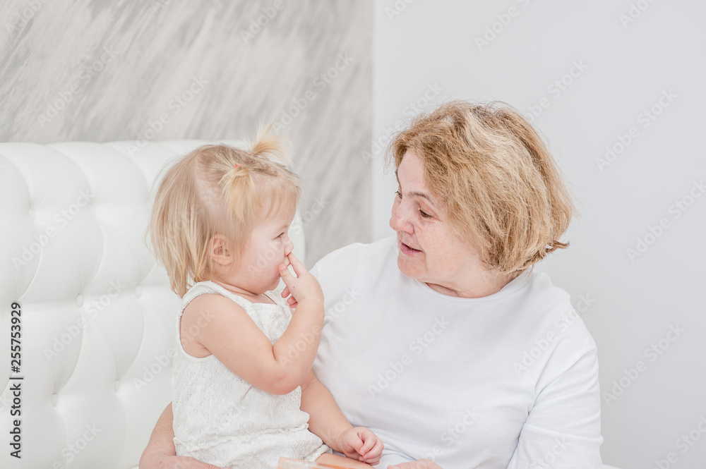 grandmother talking to her granddaughter on the bed before bedtime grandmother talking to her granddaughter on the bed before bedtime