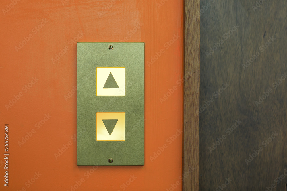 A lit elevator button A lit elevator button