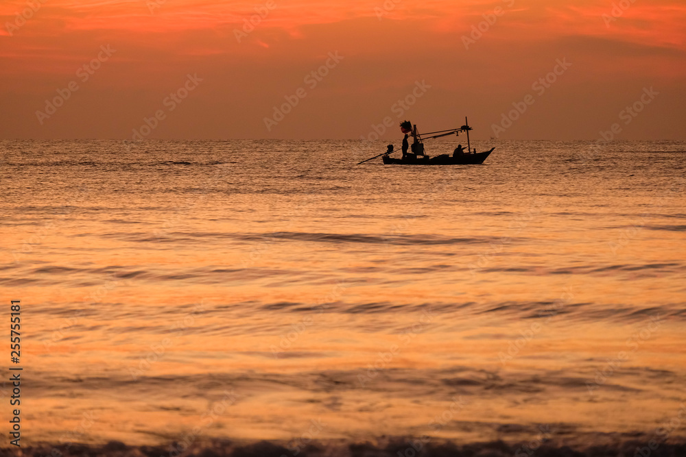 Silhouette of fisherman boat in the sea with sunrise 