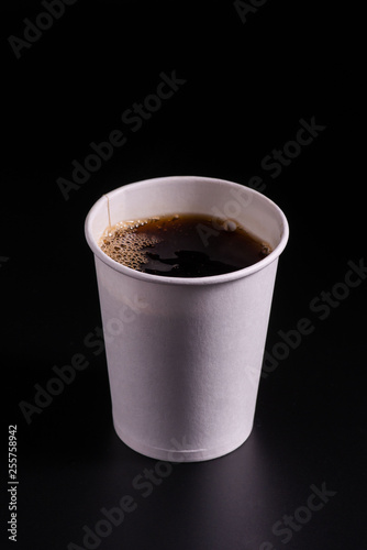 coffee pouring into disposable paper cup on a black background, takeaway coffee cup, moke up