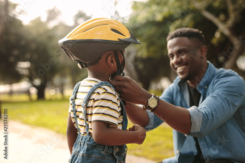 Father helping his son to wear a cycling helmet © Jacob Lund