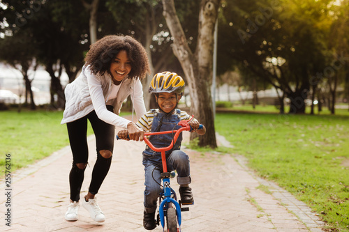 Mother teaching son to ride bicycle