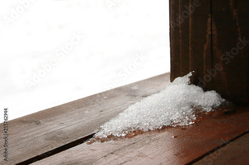 Melted snow on the wooden floor of the veranda