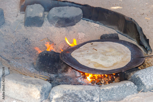 Traditional arabic pita bread cooking on fire in bedouin dwelling