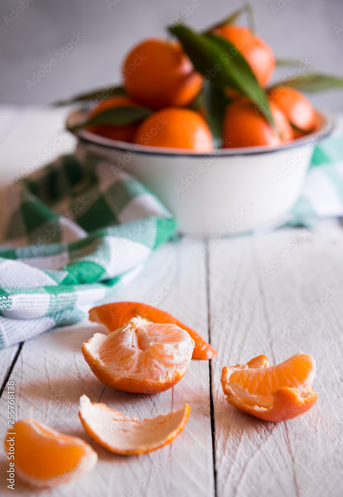 Ripe delicious mandarines with zest on white wooden table Ripe delicious mandarines with zest on white wooden table