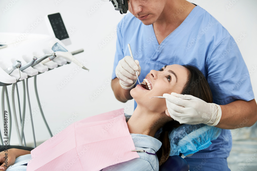 Charming woman being examined by dentist at modern clinic Charming woman being examined by dentist at modern clinic