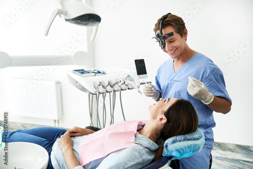 Charming young lady looking at dentist and smiling