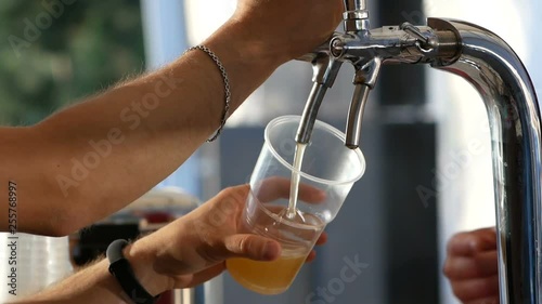 man pouring a draft beer into a plastics glass
