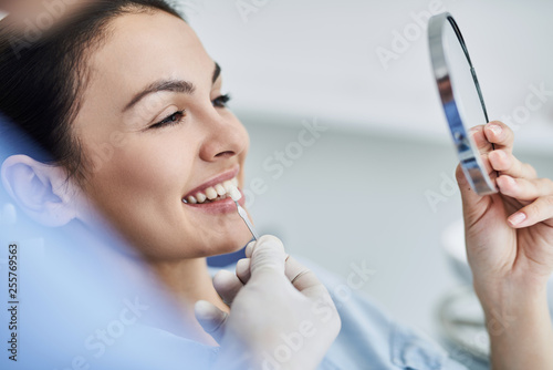 Dentist checking and selecting color of teeth for lady