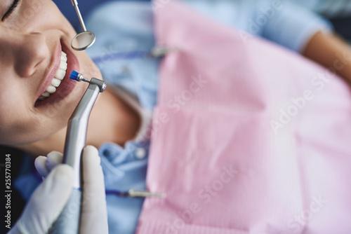 Young lady lying in dentist chair during dental procedure