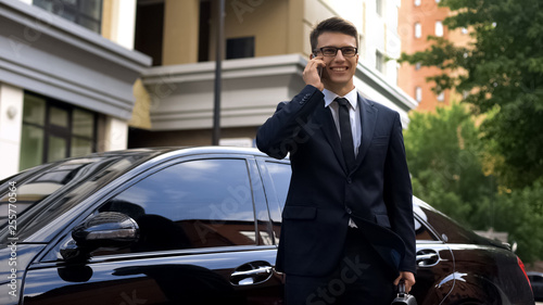 Businessman receiving good news, talking on phone near luxury car, success © motortion