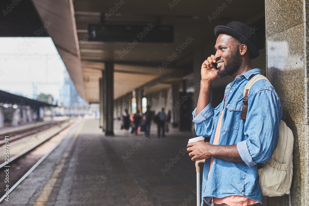 Handsome man talking on phone at railway station Handsome man talking on phone at railway station
