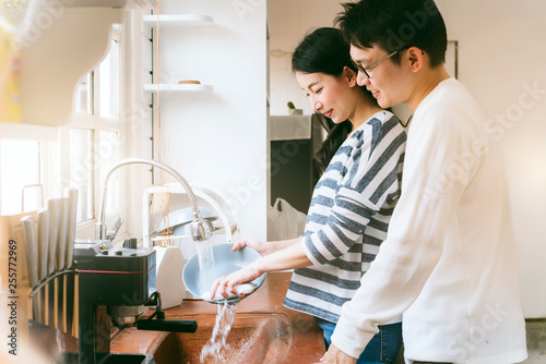 Tableau sur toile attractive couple husband and wife asian family Wash dishes together with smile