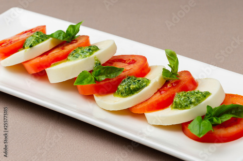 salad with fresh tomatoes, cheese and greens on a white plate