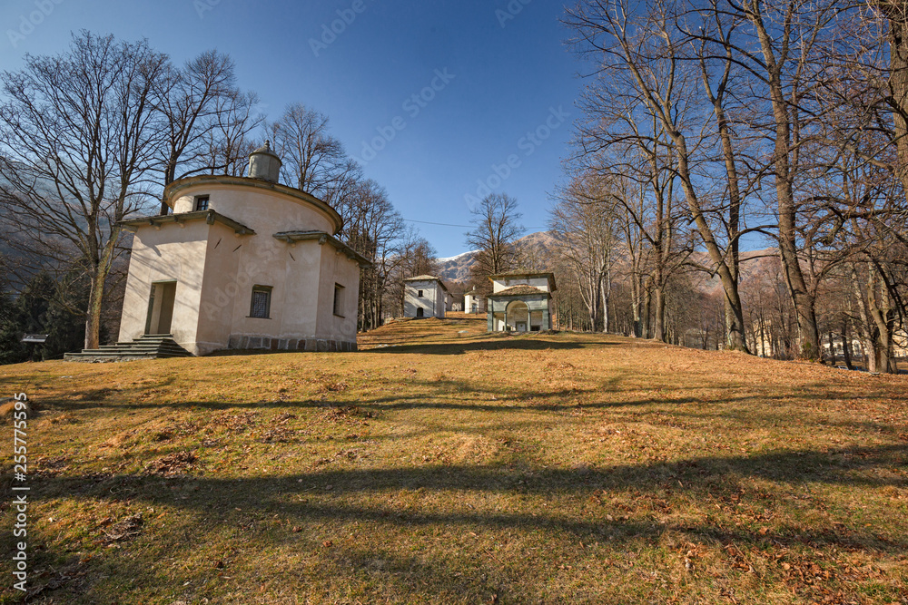 Obraz premium Panoramic view in the afternoon light on a winter day, of the seventeenth-century chapels of the monumental complex dedicated to the Virgin Mary, of the Sanctuary of Oropa in Piedmont, Italy.