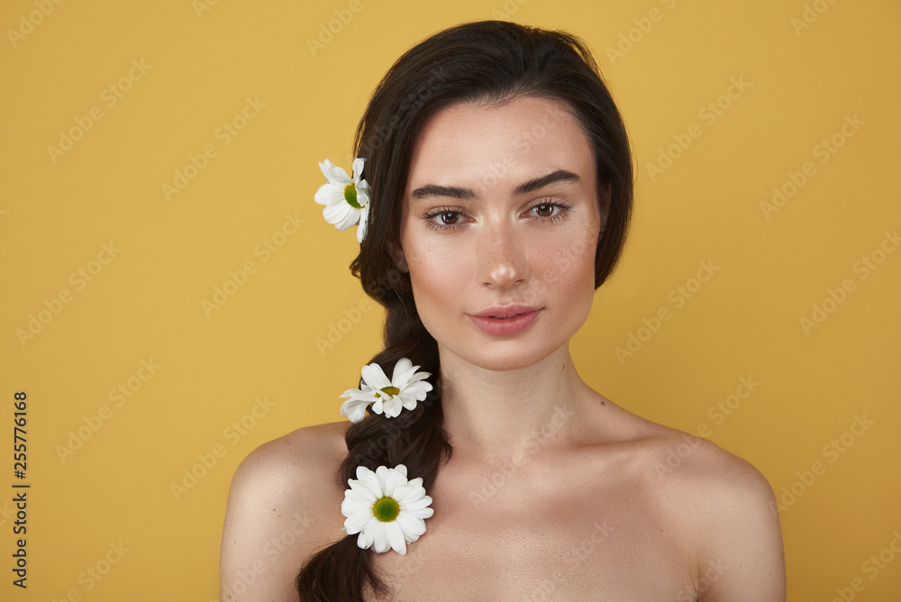 Close up of brunette woman with camomiles in hair Close up of brunette woman with camomiles in hair