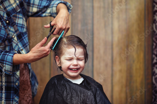A little boy is trimmed in the hairdresser's