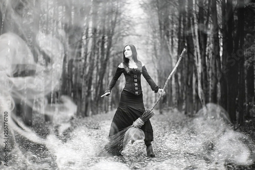 Woman in a witch suit in a dense forest © alexkich