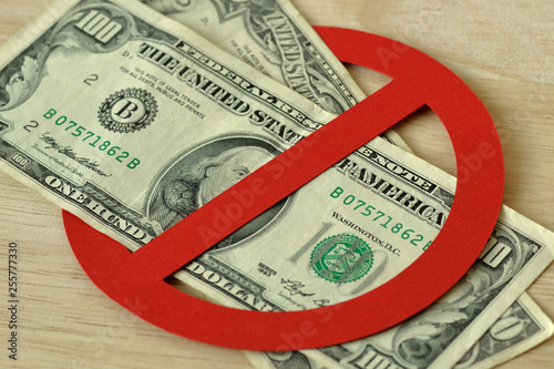 Close-up of dollar bank notes in prohibition sign - No money concept