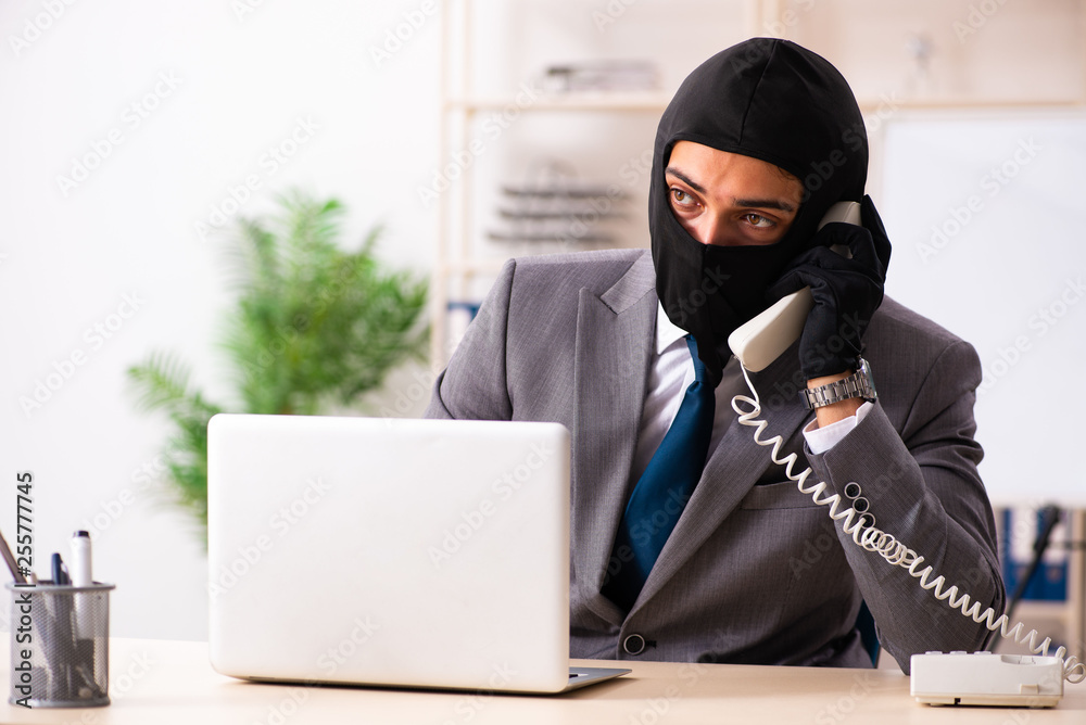 Male gangster stealing information from the office Male gangster stealing information from the office