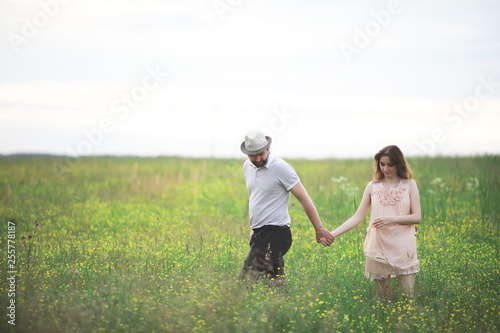 Couple man and pregnant girl in the field